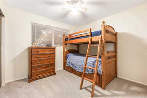 Bedroom featuring baseboards, ceiling fan, and light colored carpet