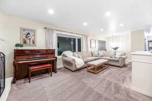 Living room with light carpet, baseboards, and recessed lighting