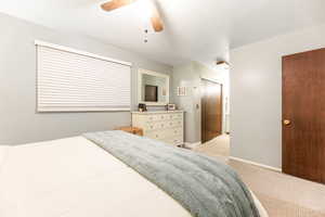 Bedroom featuring light carpet, ceiling fan, and baseboards