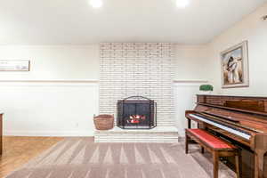 Sitting room with a fireplace, baseboards, and wood finished floors