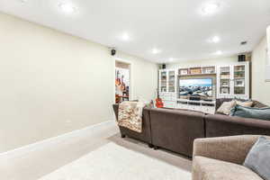 Living room featuring recessed lighting, light carpet, and baseboards