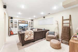 Living room featuring recessed lighting, light colored carpet, visible vents, and baseboards