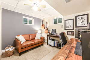 Office space with ceiling fan, a textured ceiling, visible vents, baseboards, and carpet