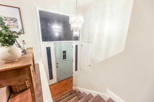 Stairway with a notable chandelier and wood finished floors