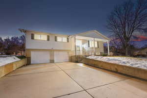 Split foyer home featuring brick siding, driveway, and an attached garage