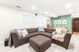 Living room with light carpet, baseboards, visible vents, and recessed lighting