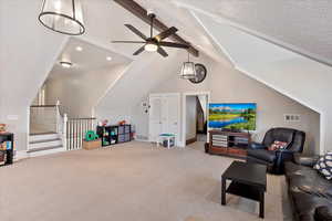 Living area with lofted ceiling with beams, ceiling fan, a textured ceiling, light carpet, and visible vents