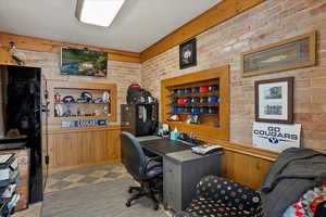 Home office with brick wall and wood walls