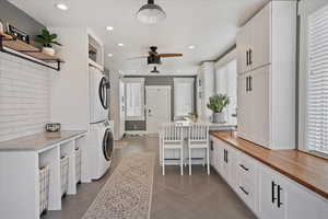 Laundry room featuring laundry area, ceiling fan, stacked washer / drying machine, a textured ceiling, and recessed lighting