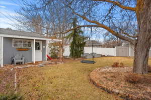 View of yard featuring a garden, a fenced backyard, and an outdoor structure