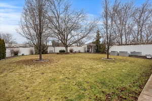 View of yard with a shed, an outdoor structure, a fenced backyard, and a vegetable garden