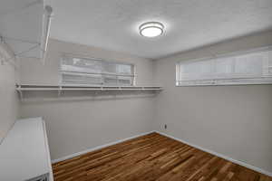 Bedroom or Walk in closet with dark wood flooring