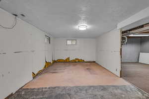 Below grade area with a textured ceiling