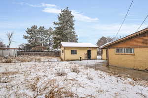 Snow covered house featuring fence