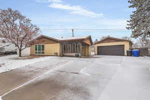 View of front of home featuring a detached garage and covered patio