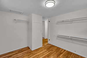 Spacious bedroom with closet and wood finished floors