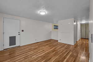 Spare room featuring a textured ceiling and light wood-type flooring