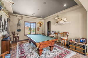 Rec room featuring visible vents, arched walkways, a raised ceiling, pool table, and recessed lighting