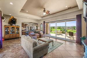 Living room featuring visible vents, arched walkways, and a raised ceiling