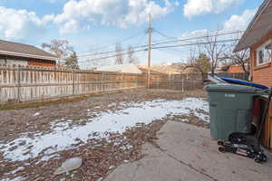 Yard covered in snow featuring a fenced backyard