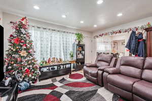 Living room featuring a textured ceiling and recessed lighting