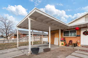 View of patio featuring a carport and fence