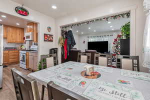 Kitchen featuring white appliances, light wood finished floors, dark countertops, open floor plan, and recessed lighting