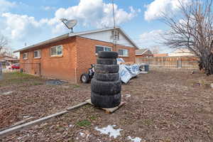 Rear view of house featuring brick siding and fence