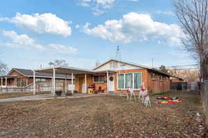 View of front of house featuring brick siding, fence, a carport, and concrete driveway