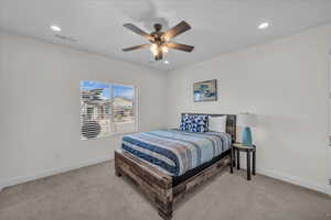 Bedroom featuring visible vents, light carpet, and baseboards