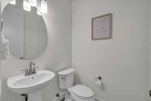 Bathroom with baseboards, a sink, and toilet