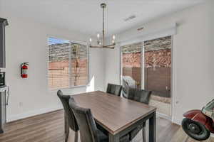 Dining space with a notable chandelier, baseboards, and wood finished floors