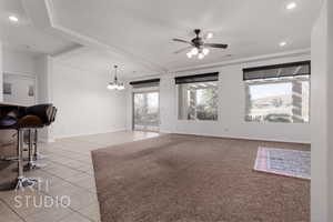 Unfurnished living room with light tile patterned floors, ceiling fan, recessed lighting, a chandelier, and baseboards