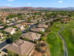 Aerial perspective of suburban area featuring mountains and a golf course