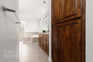 Full bath with vanity, tile patterned floors, and a garden tub