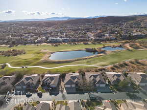 Aerial view of property's location with nearby suburban area, a golf club, and a water and mountain view