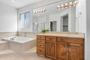 Bathroom featuring a stall shower, vanity, a garden tub, light tile patterned flooring, and recessed lighting