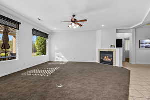 Unfurnished living room featuring a tile fireplace, light colored carpet, a ceiling fan, recessed lighting, and light tile patterned floors
