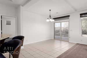 Dining room featuring a chandelier, light tile patterned floors, and baseboards