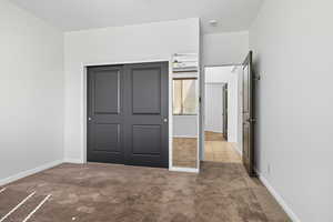 Unfurnished bedroom featuring a closet and carpet flooring