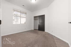 Unfurnished bedroom featuring carpet, baseboards, and a closet