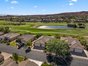 Aerial perspective of suburban area featuring a local golf course and a water and mountain view