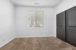 Unfurnished bedroom with carpet floors and a closet