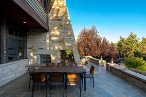 View of patio with an outdoor stone fireplace