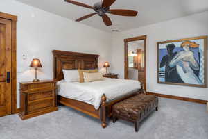 Carpeted bedroom featuring ceiling fan