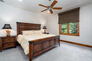 Carpeted bedroom featuring ceiling fan