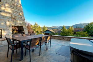 View of patio featuring a mountain view and an outdoor stone fireplace