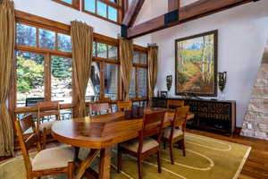 Dining room featuring wood-type flooring and a towering ceiling