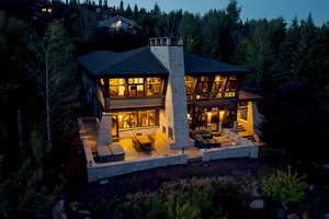 Back house at dusk featuring an outdoor living space with a fire pit and a patio