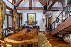 Dining space with dark hardwood / wood-style floors and a high ceiling